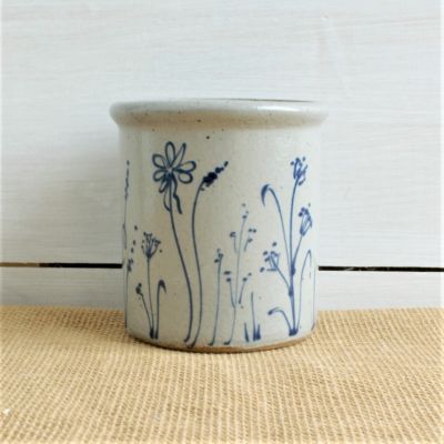           Rowe Pottery handcrafted candle crock with seasonal wildflower design with a shiplap background                  